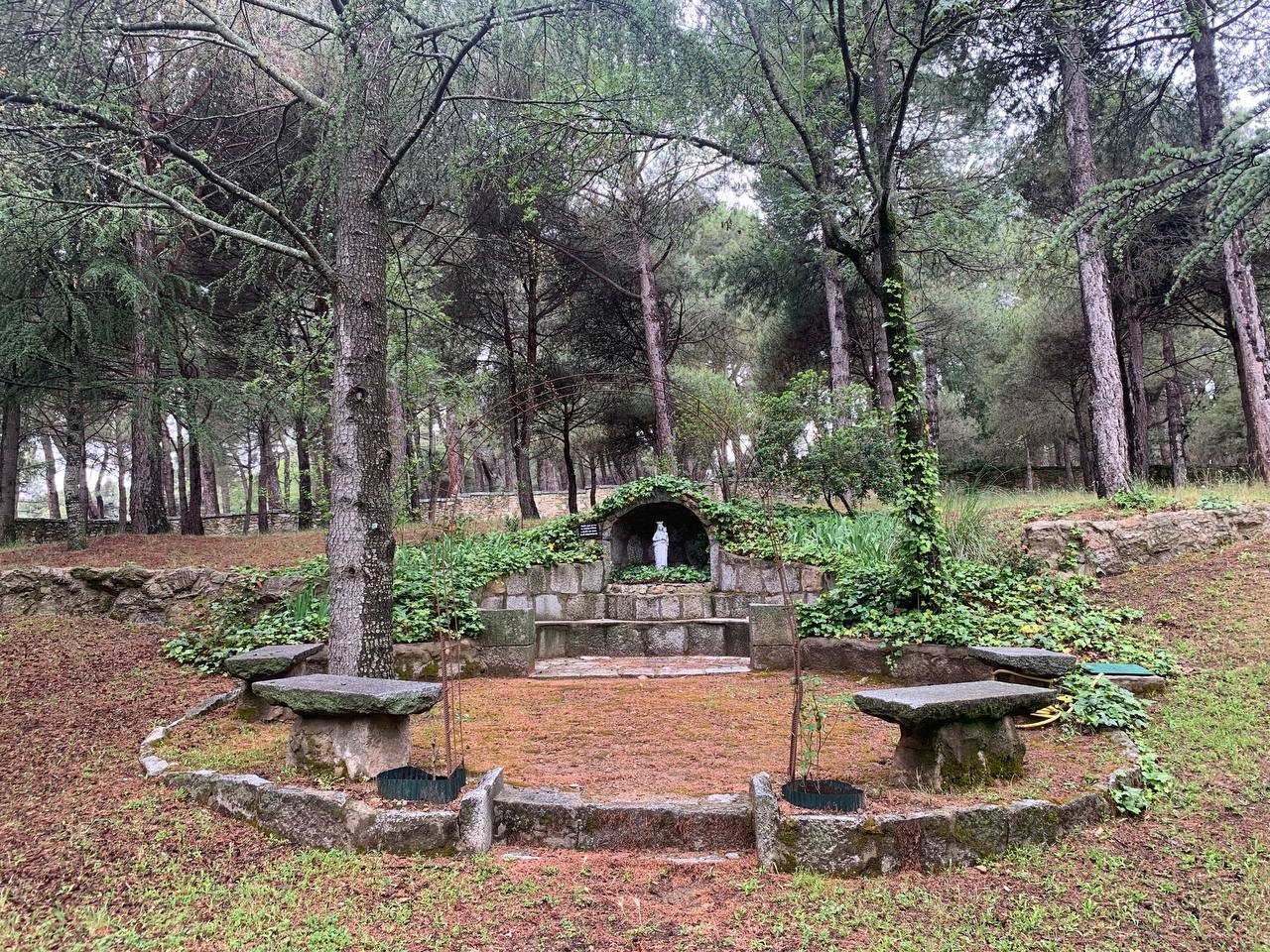 Fuente con bancos de piedra entre pinos en el lugar del retiro, en San Lorenzo de El Escorial