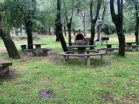 Zona de descanso con mesa redonda y bancos de piedra